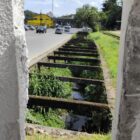 Obra em galeria de rua com casas e carros trafegando