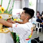 Homem jovem está em pé ajustando o adereço de cabeça de uma mulher com fantasia de carnaval