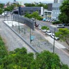 Imagem aérea de área de lazer, com playground, perto de rio