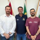 Cinco homens posam para foto e sorriem