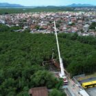 Imagem mostra grande guindaste junto a equipamento em área de mangue no local de construção da ponte Anêmonas