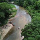 Imagem aérea de um rio com pessoas tomando banho