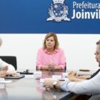 Pessoas sentadas em volta de uma mesa em reunião