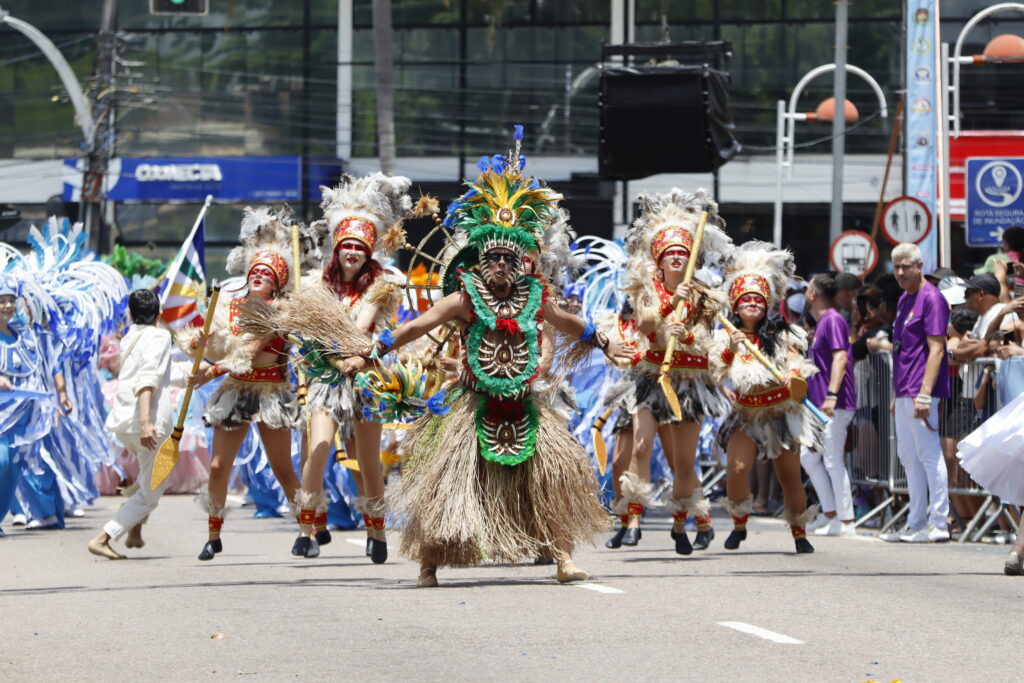Comissão de frente da escola com fantasias que remetem aos povos indígenas