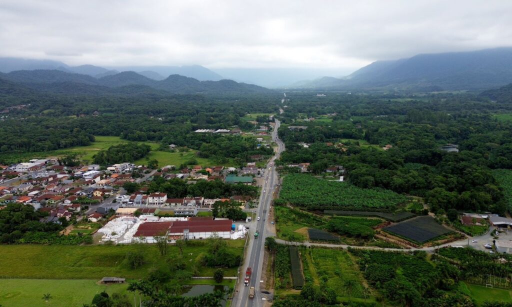 Imagem área da APA Dona Francisca mostra uma rua asfaltada ao centro e uma vasta área de vegetação com algumas construções em ambas as margens