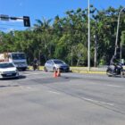 Imagem mostra erosão no asfalto de uma via movimentada com carros, moto e caminhão