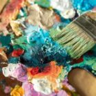 Imagem de diferentes tintas artísticas e um pincel