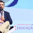 Secretário Diego Calegari sentado, com o microfone na mão