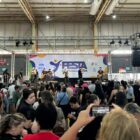 Banda de música em palco com plateia assistindo apresentação
