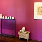 Exposição com esculturas e quadro com desenho em galeria de arte