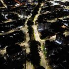 Imagem área mostra ruas iluminadas durante a noite