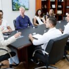 Homens e mulher reunidos em volta de uma mesa