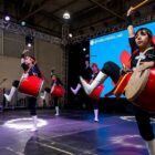 Crianças orientais tocam tambores em palco