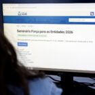 Pessoa acessa o computador com a tela na página da Prefeitura com informações sobre o 3º Seminário Força para as Entidades
