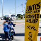 Mulher oferece folder a condutor de autopropelido em blitz educativa