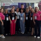 Onze pessoas, entre homens e mulheres, posam para foto em estande de Joinville em feira de turismo
