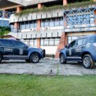 Duas viaturas azuis da Guarda Municipal estão posicionadas em frente ao prédio da Prefeitura