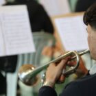 Música toca trompete lendo partitura