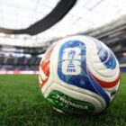 Bola da Copa em gramado em um estádio de futebol