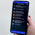 Imagem mostra mão feminina, com unhas pintadas de bordô, segurando um celular. Na tela, há uma página do aplicativo Joinville Fácil que permite fazer agendamentos