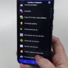 Imagem mostra mão feminina segurando um celular em uma página do aplicativo Joinville Fácil