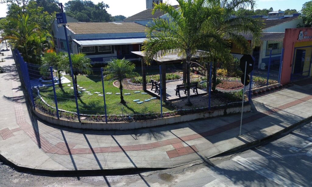 Imagem aérea mostra unidade escolar com calçada em concreto com piso podotátil