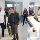 Homens e mulheres caminham por um corredor branco de hospital