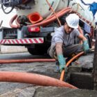 Operário de capacete utiliza hidrojato em boca de lobo
