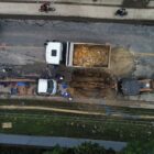 Vista área do local do reparo com máquinas, veículos e trabalhadores