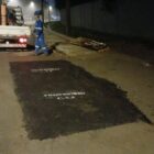 Imagem mostra trecho de rua pavimentada com asfalto mais escuro em área que passou por conserto. Logo à frente há um pequeno caminhão e um homem com uniforme