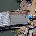 Imagem aérea mostra mangueira de caminhão despejando concreto em uma laje na Ponte Anêmonas