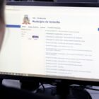 Mulher com o rosto parcialmente visível e desfocado observa tela de computador em página do TMI, sistema tributário da Prefeitura de Joinville