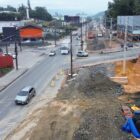 Imagem aérea mostra o cruzamento entre duas ruas asfaltadas. No local, há máquinas que mostram que o local está em obras