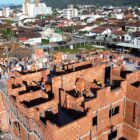 Prédio em construção cercado de casas