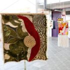 Imagem mostra flâmula em tecidos em diversas texturas e desenhos em uma exposição