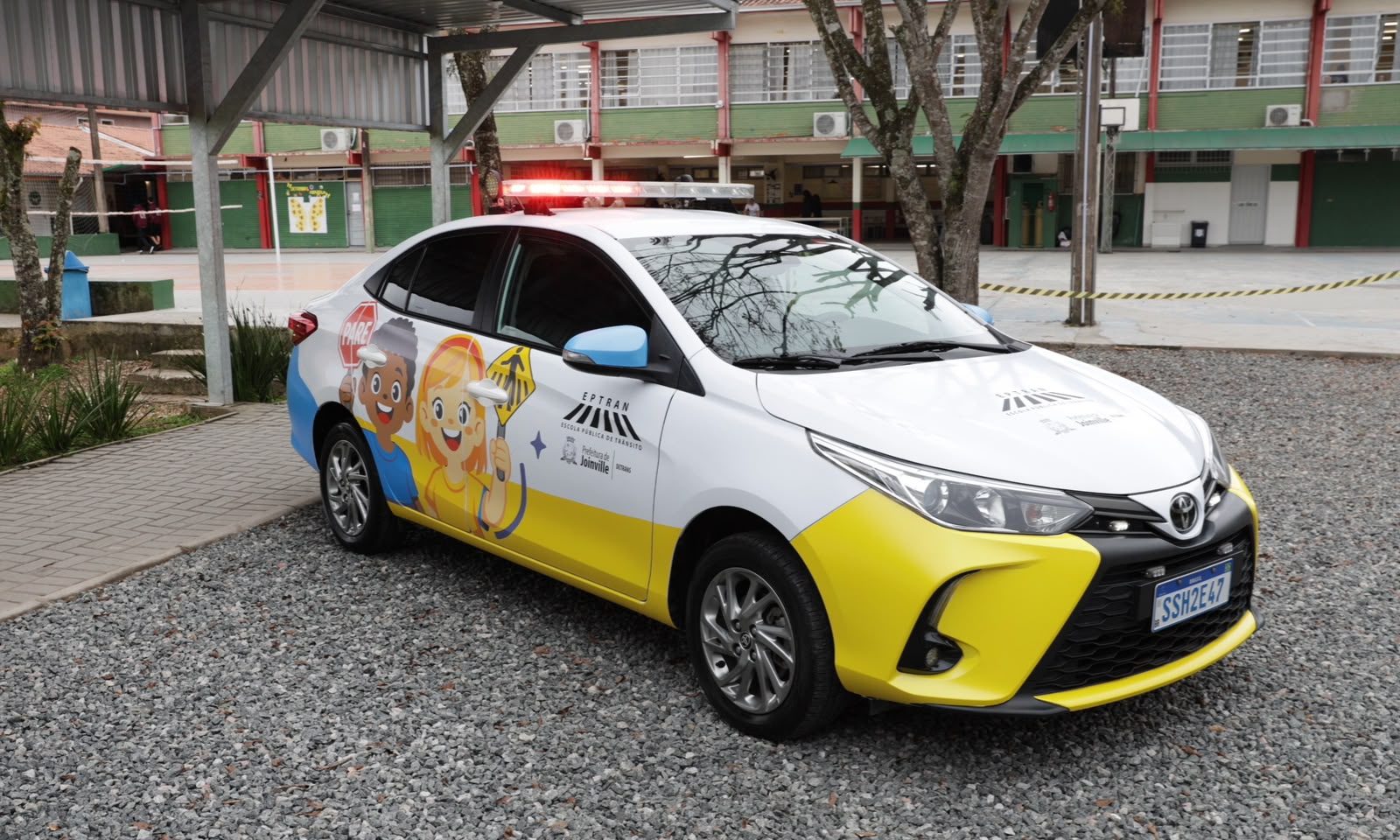 Carro sedã branco plotado a imagem em desenho de duas crianças