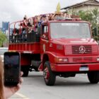 Atletas desfilam em cima de caminhão dos bombeiros