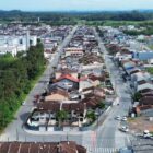 Foto área mostra duas ruas pavimentadas e paralelas cercadas por imóveis em uma área residencial