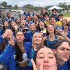 Foto mostra dezenas de adolescentes com uniforme azul posando para uma foto selfie. Alguns mostram medalhas.
